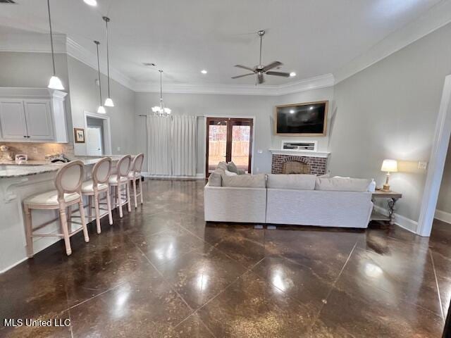 living room featuring crown molding, ceiling fan, and a brick fireplace