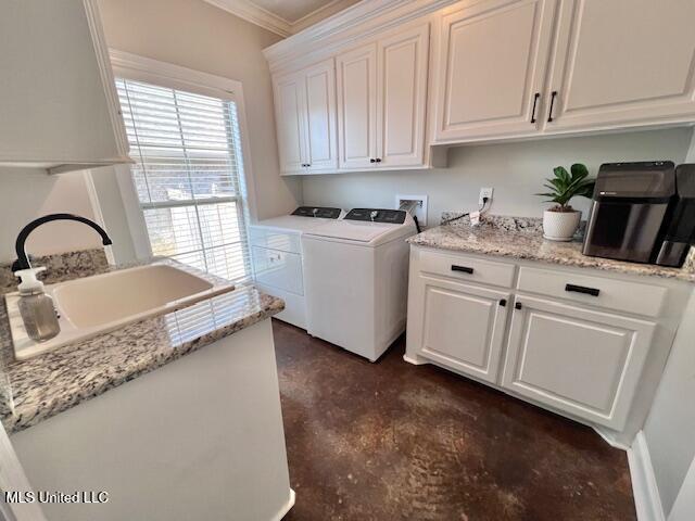 laundry room featuring sink, ornamental molding, cabinets, and washing machine and clothes dryer