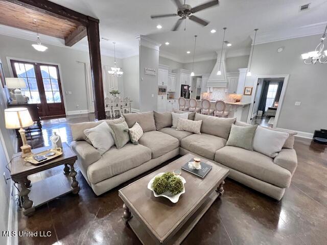 living room featuring crown molding, plenty of natural light, french doors, and ceiling fan with notable chandelier