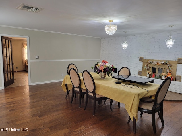 166 Lee Ave, Vidalia, LA 71373 - dining space featuring a chandelier, wood finished floors, brick wall, ornamental molding, and baseboards