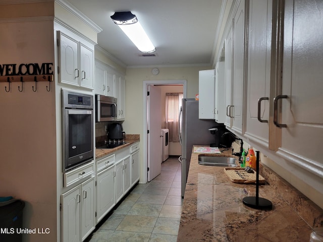 166 Lee Ave, Vidalia, LA 71373 - kitchen with appliances with stainless steel finishes, washer and clothes dryer, white cabinetry, decorative backsplash, and ornamental molding