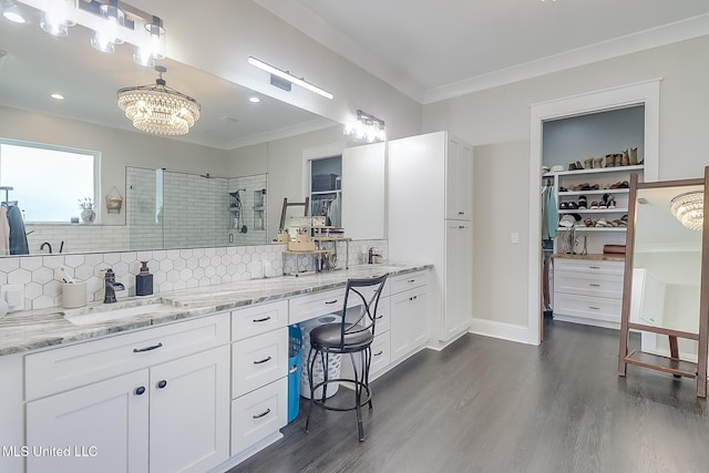 bathroom with a shower, backsplash, hardwood / wood-style flooring, vanity, and crown molding