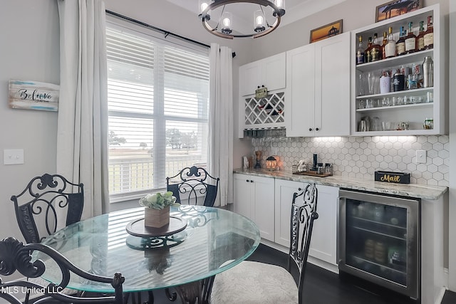 dining area featuring wine cooler, indoor bar, and an inviting chandelier