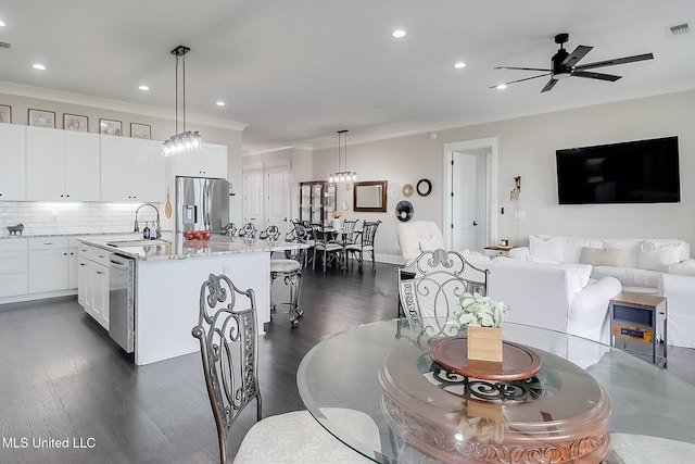 kitchen featuring sink, white cabinetry, hanging light fixtures, an island with sink, and stainless steel appliances