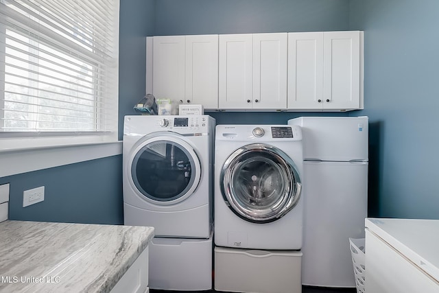 laundry room featuring cabinets and washing machine and clothes dryer