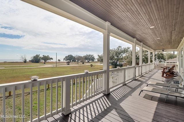 wooden deck with covered porch and a lawn