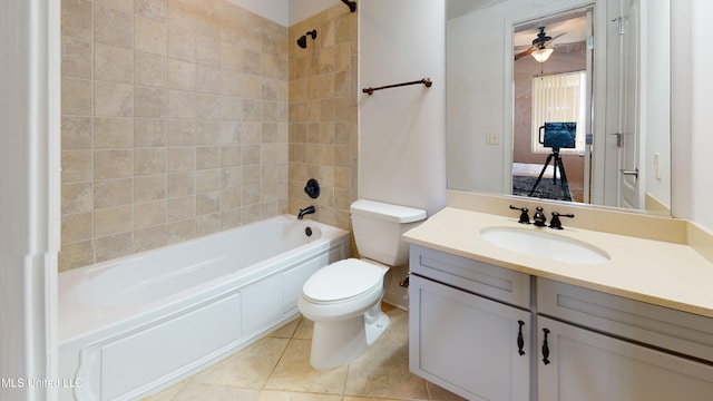 full bathroom with ceiling fan, toilet, vanity, tiled shower / bath combo, and tile patterned floors