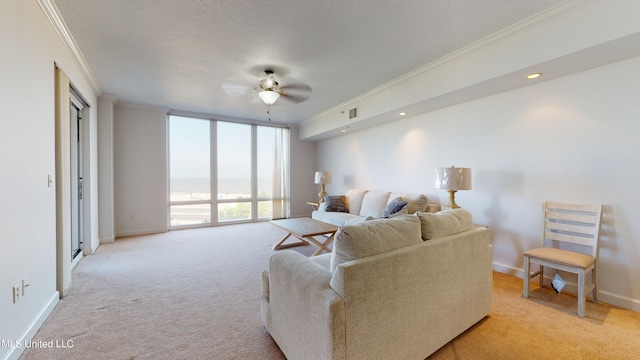 carpeted living room featuring ceiling fan, ornamental molding, and a textured ceiling