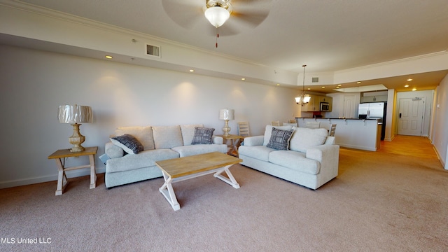 living room with light colored carpet, ornamental molding, and ceiling fan with notable chandelier