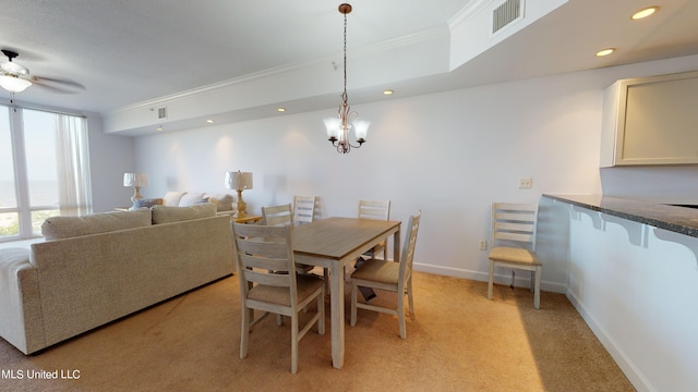 carpeted dining area featuring ceiling fan with notable chandelier