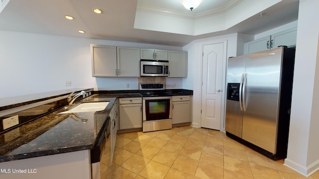 kitchen featuring appliances with stainless steel finishes, light tile patterned flooring, sink, dark stone countertops, and crown molding