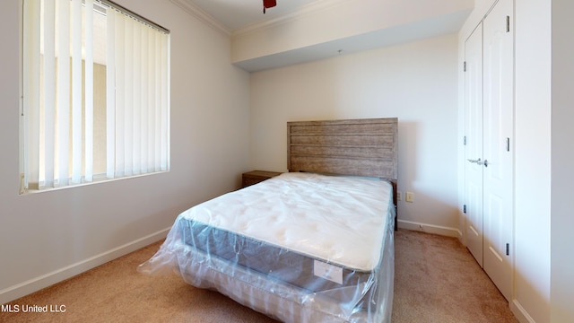 carpeted bedroom featuring crown molding and ceiling fan