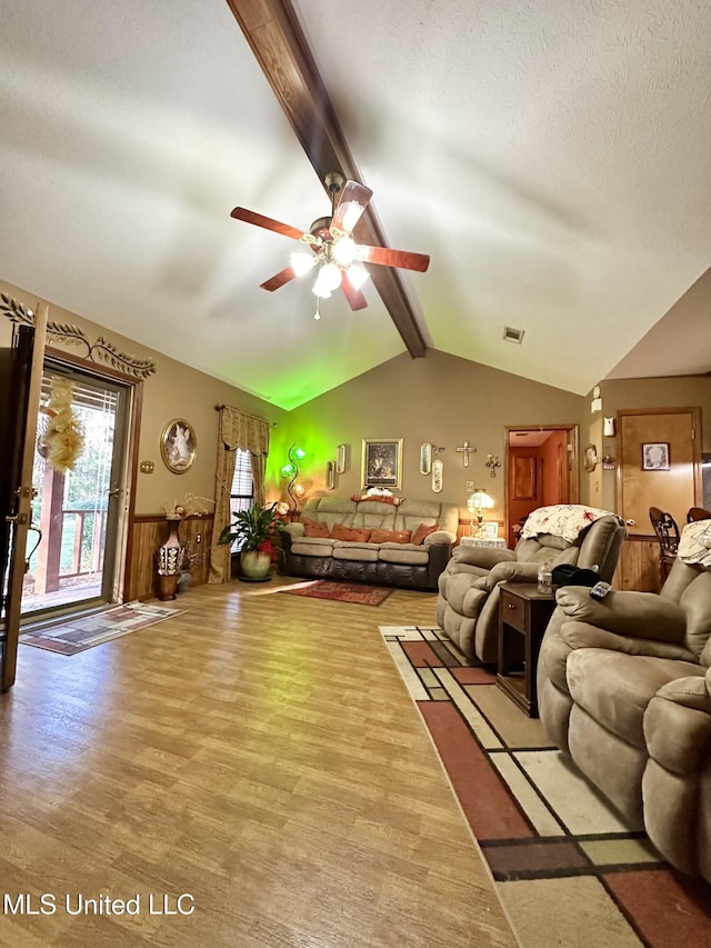 living room featuring ceiling fan, hardwood / wood-style floors, lofted ceiling with beams, and a textured ceiling