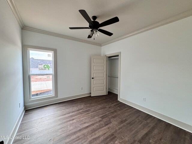 unfurnished bedroom featuring crown molding, dark wood-type flooring, and ceiling fan