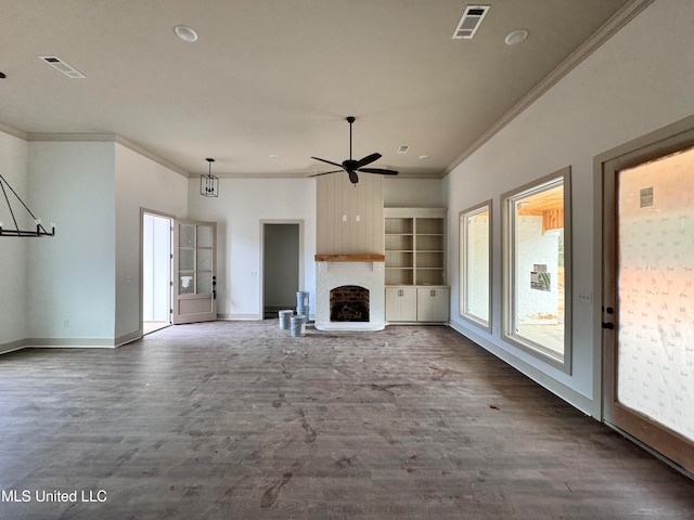 unfurnished living room featuring built in shelves, dark hardwood / wood-style floors, ornamental molding, and a fireplace