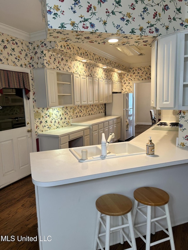 8136 Saddlebrook Cv, Olive Branch, MS 38654 - kitchen with wallpapered walls, freestanding refrigerator, open shelves, ornamental molding, and a peninsula