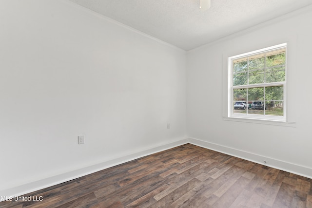 empty room with ornamental molding, a textured ceiling, and dark hardwood / wood-style flooring