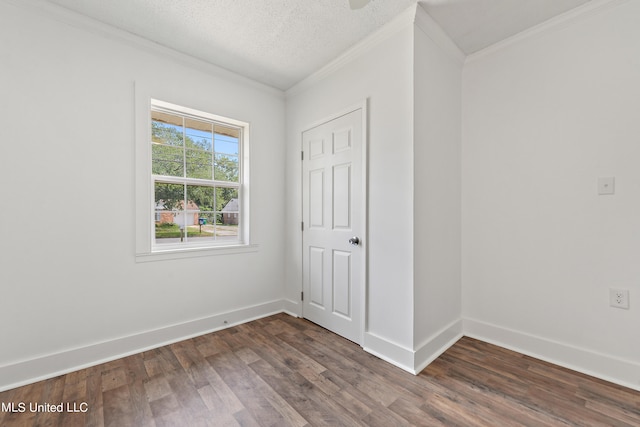 spare room with dark wood-type flooring, crown molding, and a textured ceiling