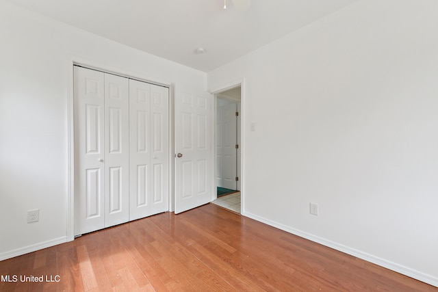 unfurnished bedroom with a closet and light hardwood / wood-style floors