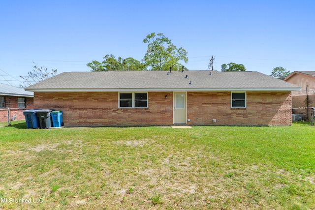 rear view of house featuring a yard