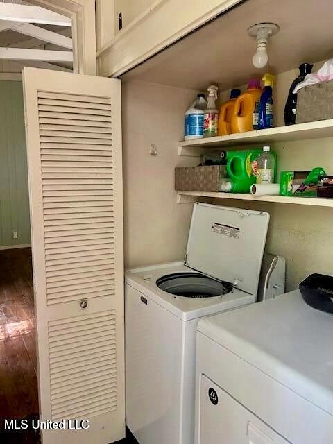 clothes washing area with washing machine and clothes dryer, laundry area, and wood finished floors