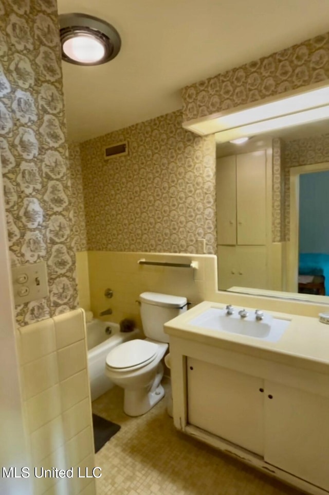 full bathroom with vanity, toilet, wallpapered walls, and visible vents