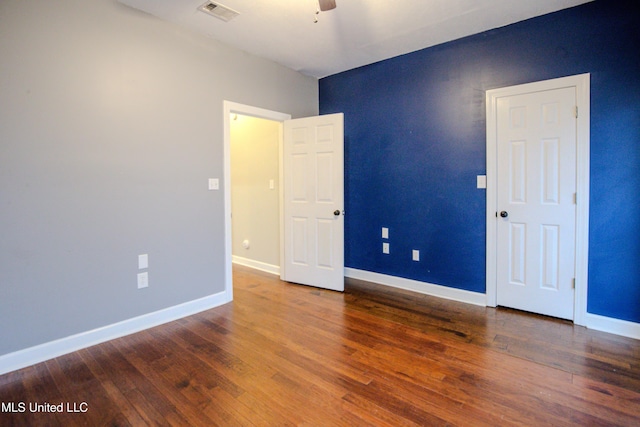 unfurnished room featuring dark wood-type flooring and ceiling fan