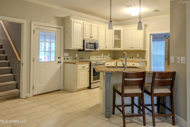 kitchen featuring a kitchen breakfast bar, appliances with stainless steel finishes, and white cabinets