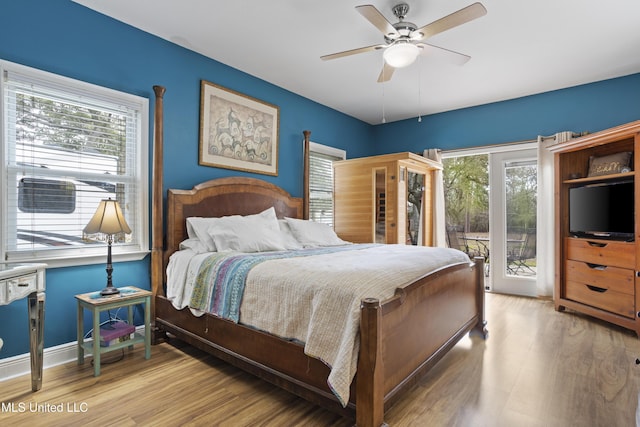 bedroom with access to outside, multiple windows, baseboards, and light wood-style flooring