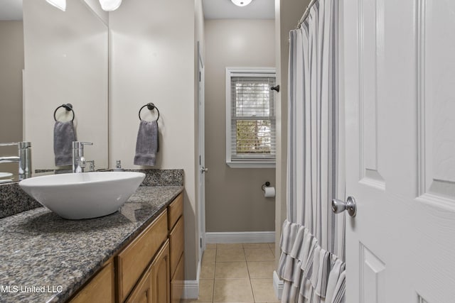 bathroom with vanity, baseboards, and tile patterned floors