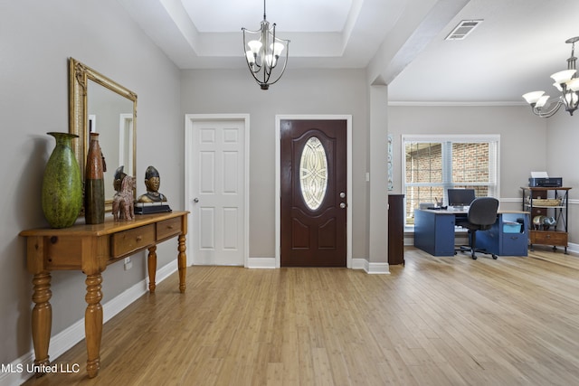 entryway with a chandelier, visible vents, baseboards, light wood-style floors, and a tray ceiling