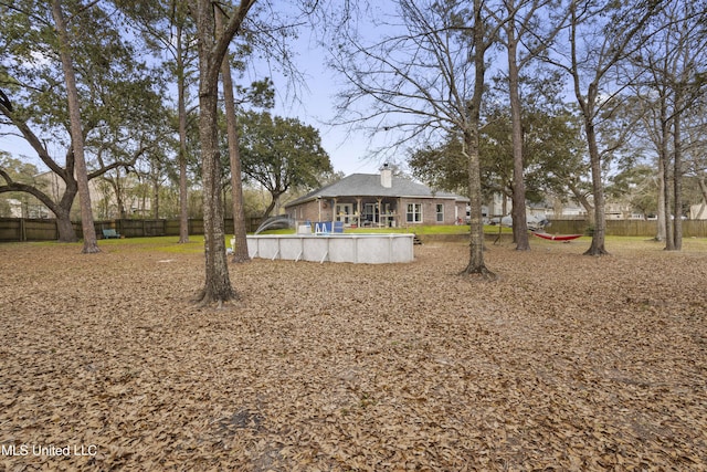 view of yard with an outdoor pool and fence