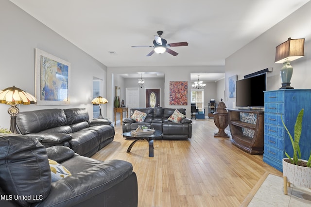 living area with light wood-type flooring, visible vents, and ceiling fan with notable chandelier