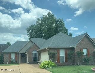 ranch-style home with a front lawn, a garage, and driveway