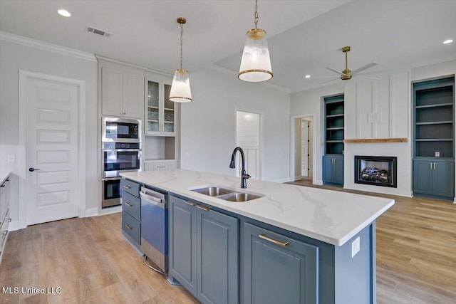 104 Brents Xing, Clinton, MS 39056 - kitchen with stainless steel appliances, a sink, ornamental molding, an island with sink, and light wood-type flooring