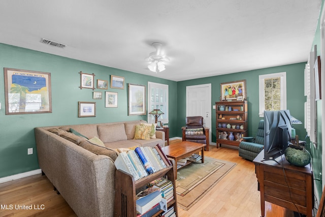 living room with light hardwood / wood-style flooring and ceiling fan