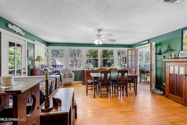 dining space featuring ceiling fan, a textured ceiling, and light hardwood / wood-style flooring