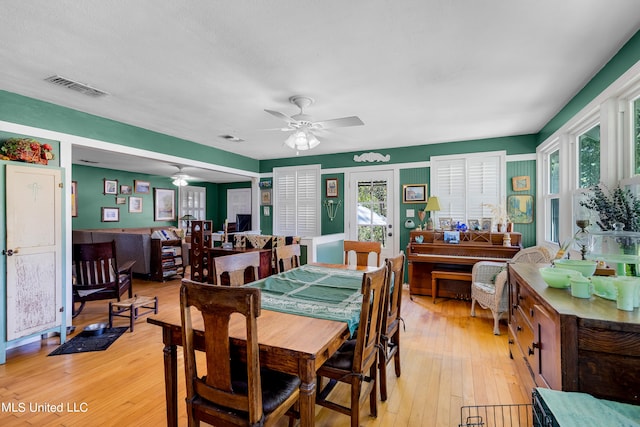 dining space with light hardwood / wood-style flooring and ceiling fan