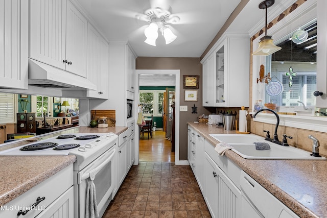 kitchen with white cabinetry, sink, plenty of natural light, and white appliances