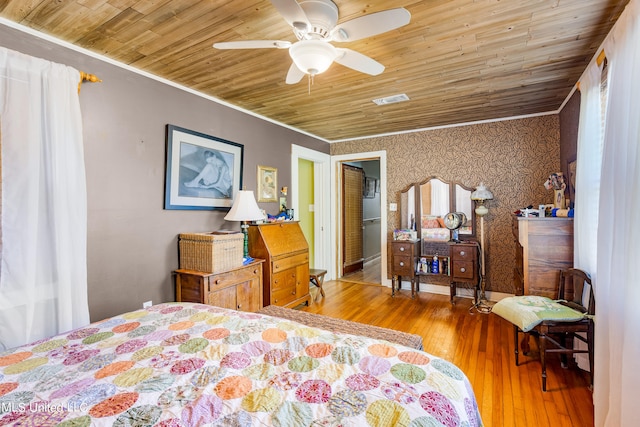 bedroom with ceiling fan, hardwood / wood-style flooring, wooden ceiling, and crown molding