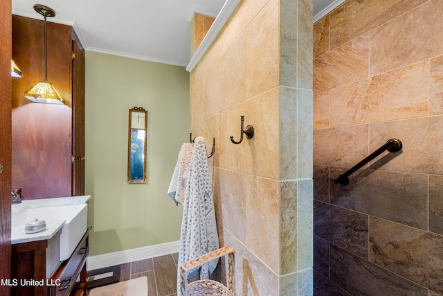 bathroom with vanity, crown molding, a tile shower, and hardwood / wood-style floors