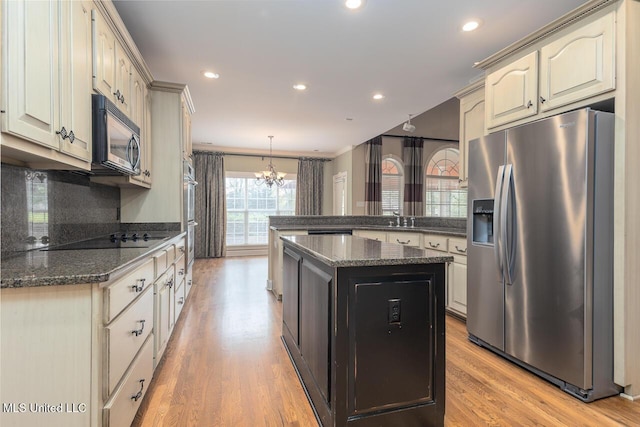8679 Saddle Creek Dr, Olive Branch, MS 38654 - kitchen featuring appliances with stainless steel finishes, a peninsula, a chandelier, light wood-style floors, and recessed lighting