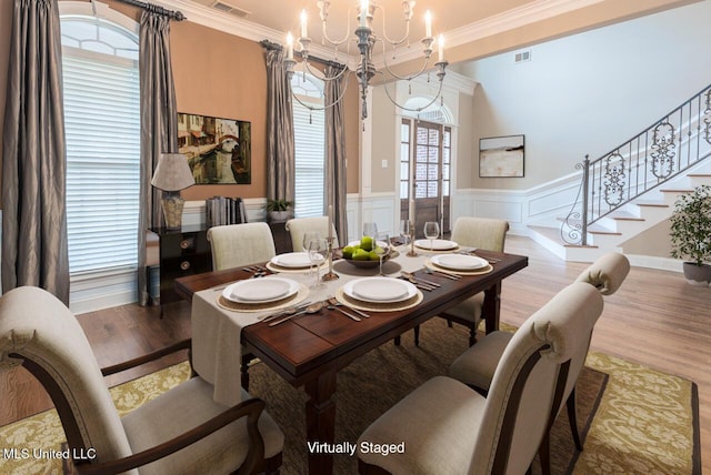 8679 Saddle Creek Dr, Olive Branch, MS 38654 - dining room with a chandelier, wood finished floors, crown molding, stairway, and a wainscoted wall