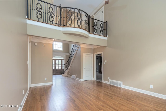 8679 Saddle Creek Dr, Olive Branch, MS 38654 - unfurnished living room featuring a high ceiling, stairs, wood finished floors, and crown molding