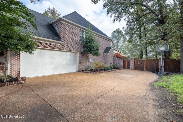 8679 Saddle Creek Dr, Olive Branch, MS 38654 - view of side of property with driveway, brick siding, and roof with shingles