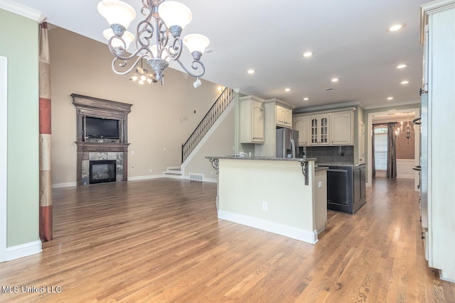 8679 Saddle Creek Dr, Olive Branch, MS 38654 - kitchen featuring a breakfast bar area, a high end fireplace, stainless steel fridge with ice dispenser, open floor plan, and glass insert cabinets