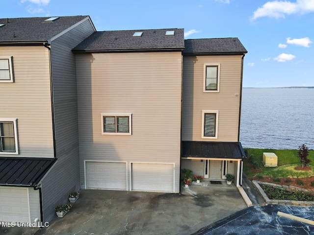 21 Breakers Ln, Ridgeland, MS 39157 - view of side of home with a water view, an attached garage, metal roof, and driveway