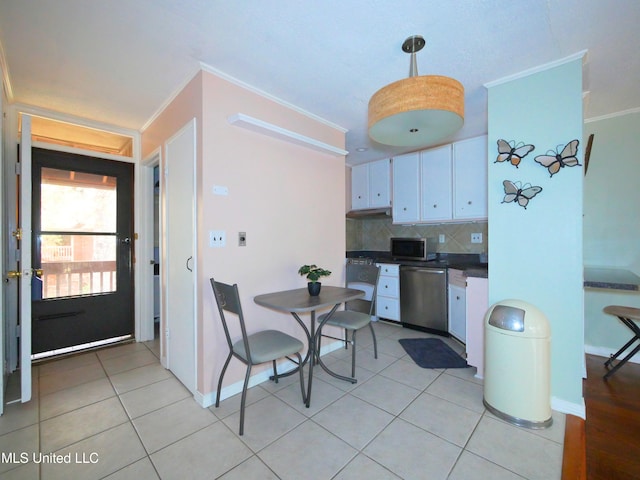 kitchen featuring tasteful backsplash, white cabinets, ornamental molding, and appliances with stainless steel finishes