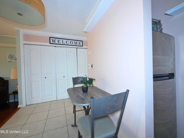 tiled dining area featuring crown molding