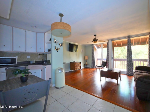 tiled living room with ceiling fan